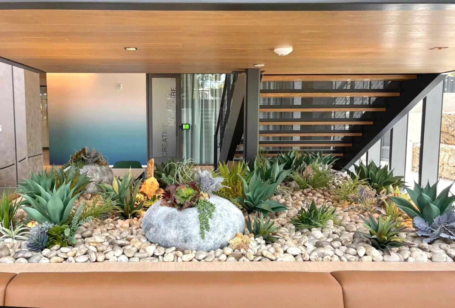 A faux succulent bed under a staircase