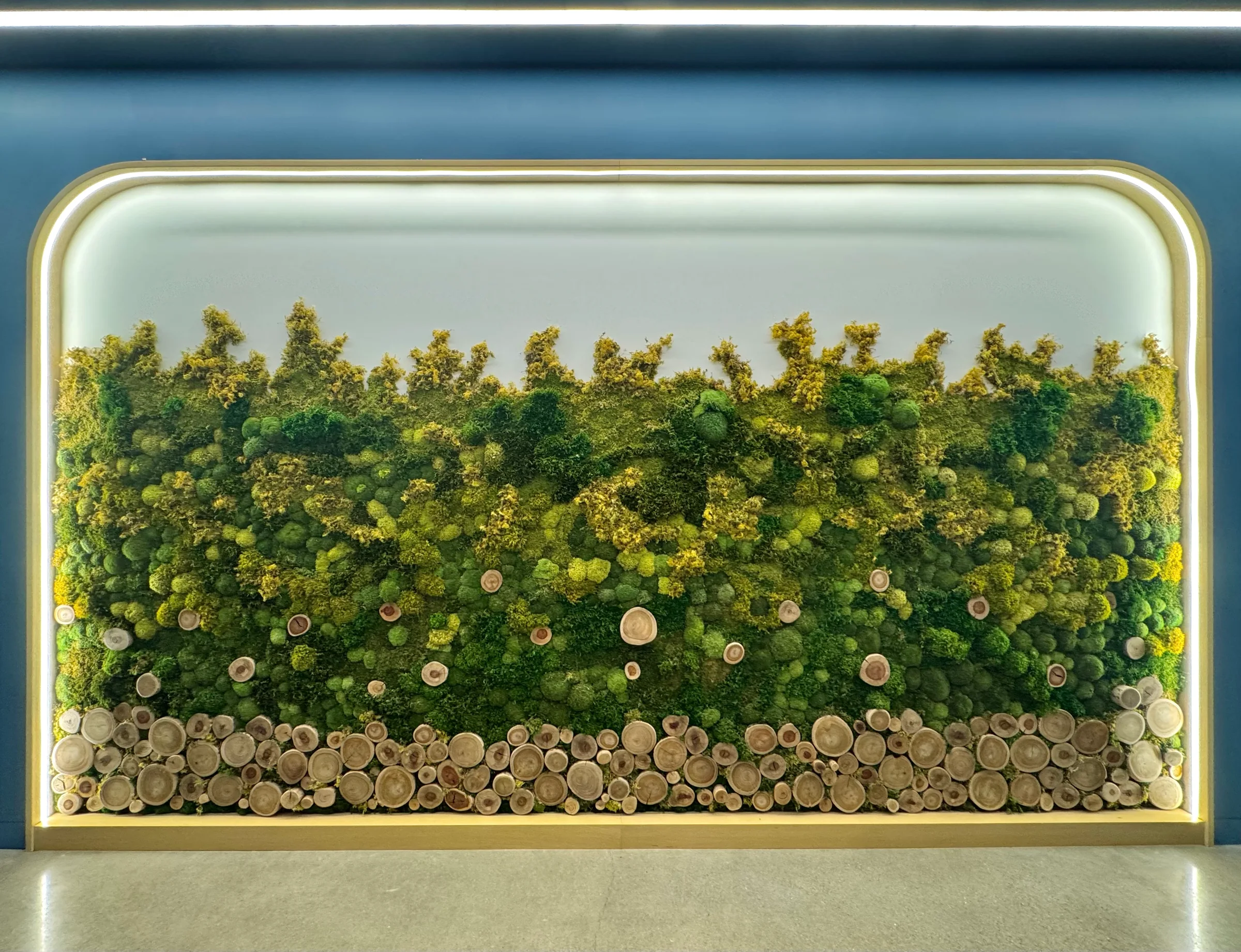 A lit preserved moss wall with wood rounds