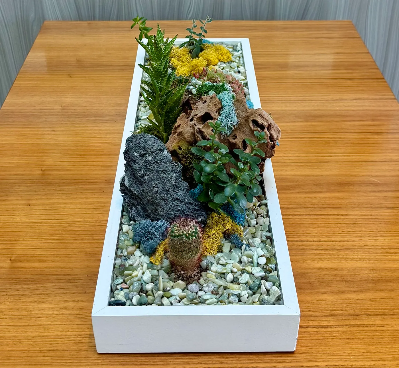A long tabletop planter with stone
